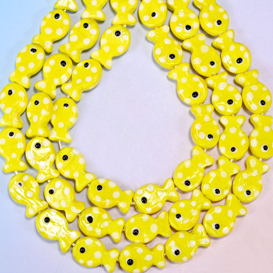 Moulded fish shaped yellow glass beads