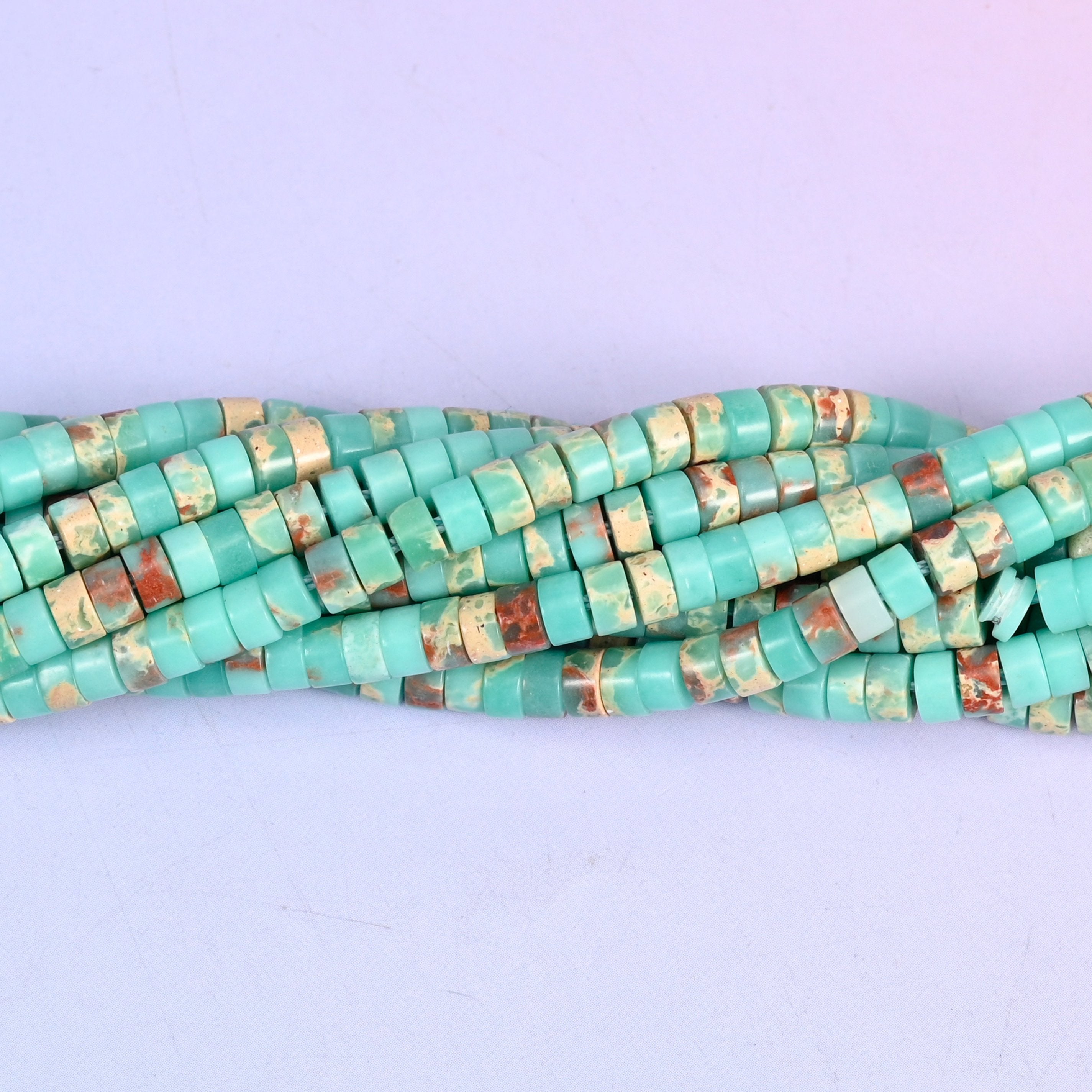 Turquoise-green mottled with rust red and cream, so each little disc looks like a slice cut through desert stone. Around a hundred and eighty to the strand.