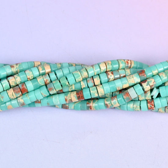 Turquoise-green mottled with rust red and cream, so each little disc looks like a slice cut through desert stone. Around a hundred and eighty to the strand.