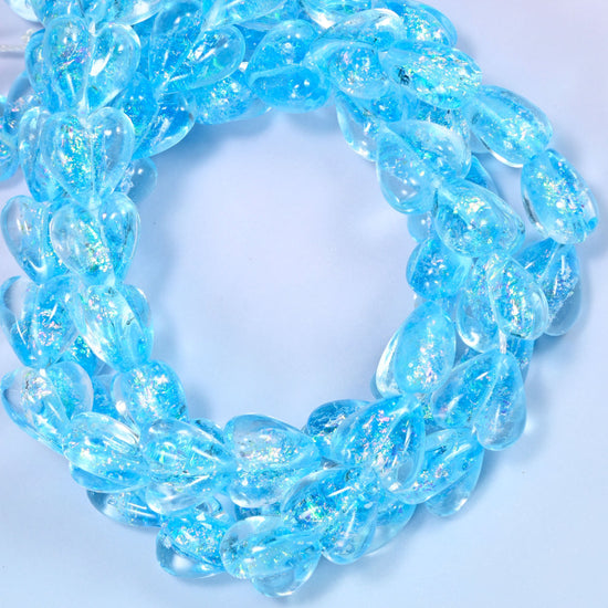 Iridescent light blue heart glass beads coiled into a ring, the full 11.5 inch strand of 24 hearts