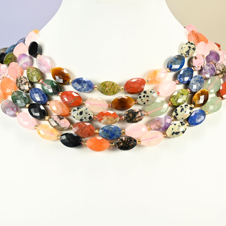 Assorted gemstone faceted flat oval strands arranged as a layered collar on a white display bust, multicolor beads across the neck