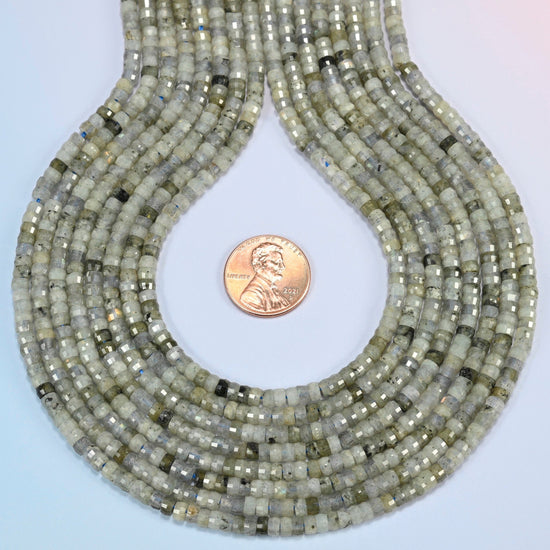 White labradorite faceted heishi disc strands formed into a teardrop loop around a US penny for scale