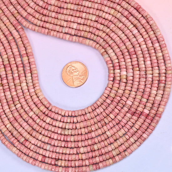 Pink Rhodonite disc beads used as spacer accents between other beads.