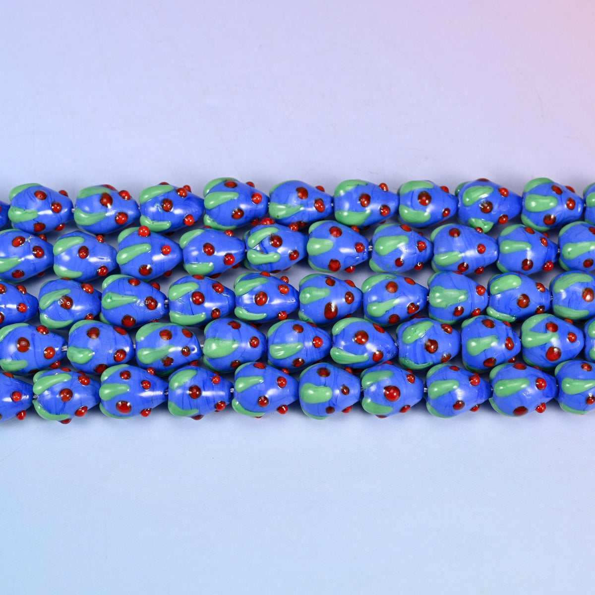 Dark Blue Red Dots Strawberry Glass Beads in glossy cobalt blue with a pale green leaf cap