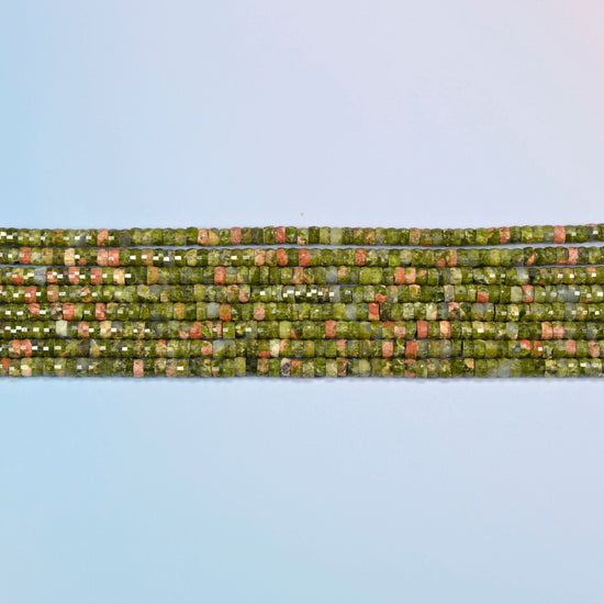 Several strands of unakite faceted heishi disc beads laid in straight rows