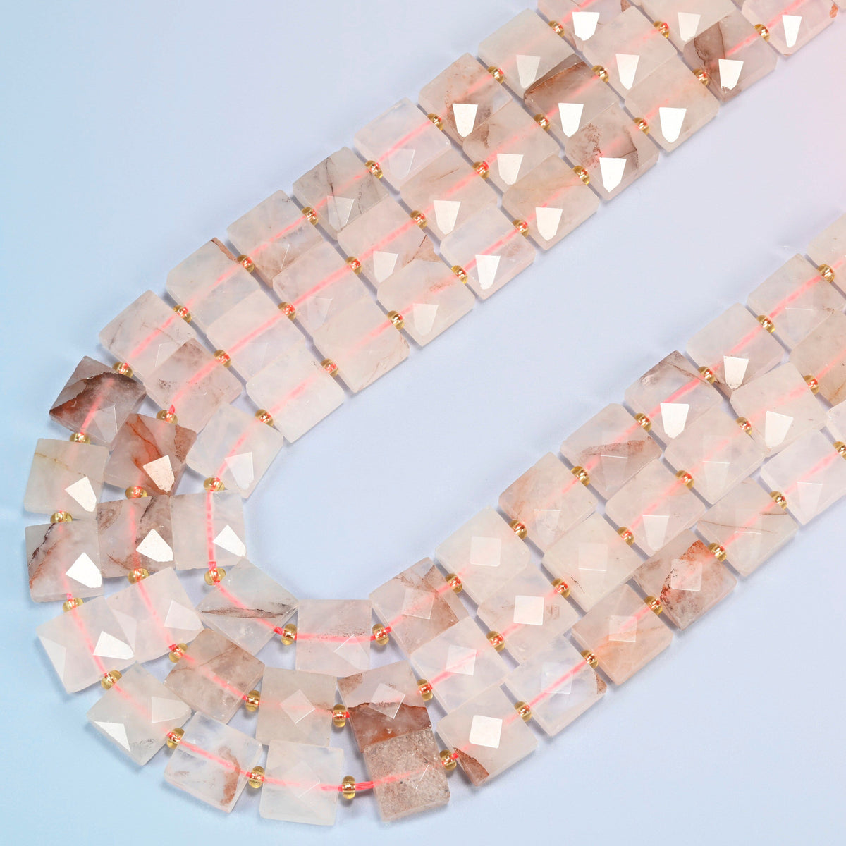 Natural red hematoid quartz faceted flat square beads in several strands curved into a wide U, frosted white and light pink stone with red-brown inclusions