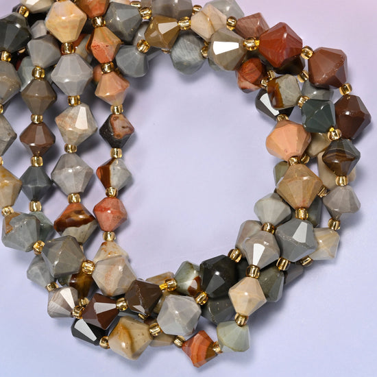 Close-up of American Picture Jasper faceted bicone beads, 8mm and 10mm, coiled into a circle, showing the multicolor tan, gray and rust banding.