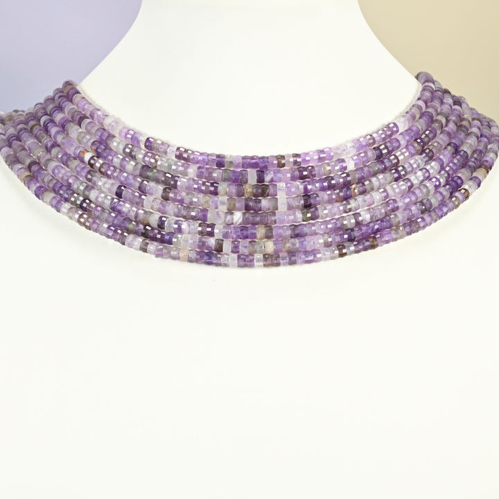 Amethyst faceted heishi disc strands arranged as a layered collar on a white display bust, purple beads across the neck