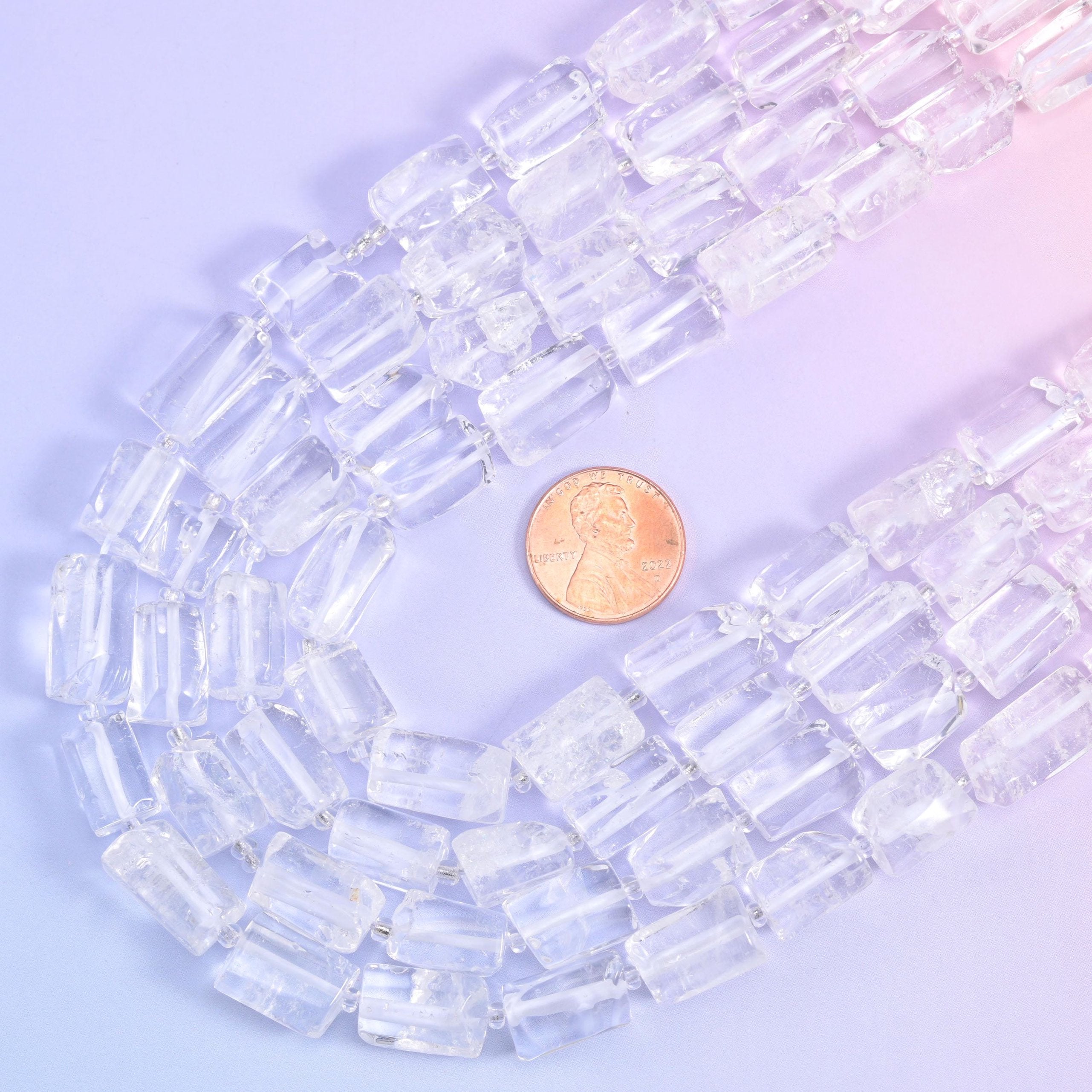 A US penny tucked into the curve of the strands gives the scale of the 14x9mm quartz tubes