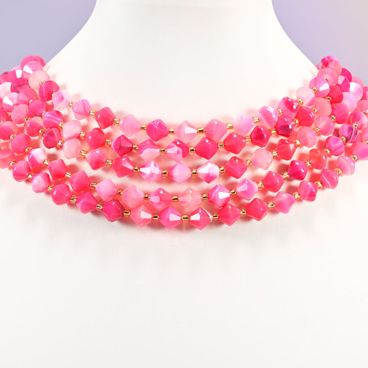 Dyed Rose Red Strip Agate bicone bead strand worn as a multi-strand choker on a display neck form.
