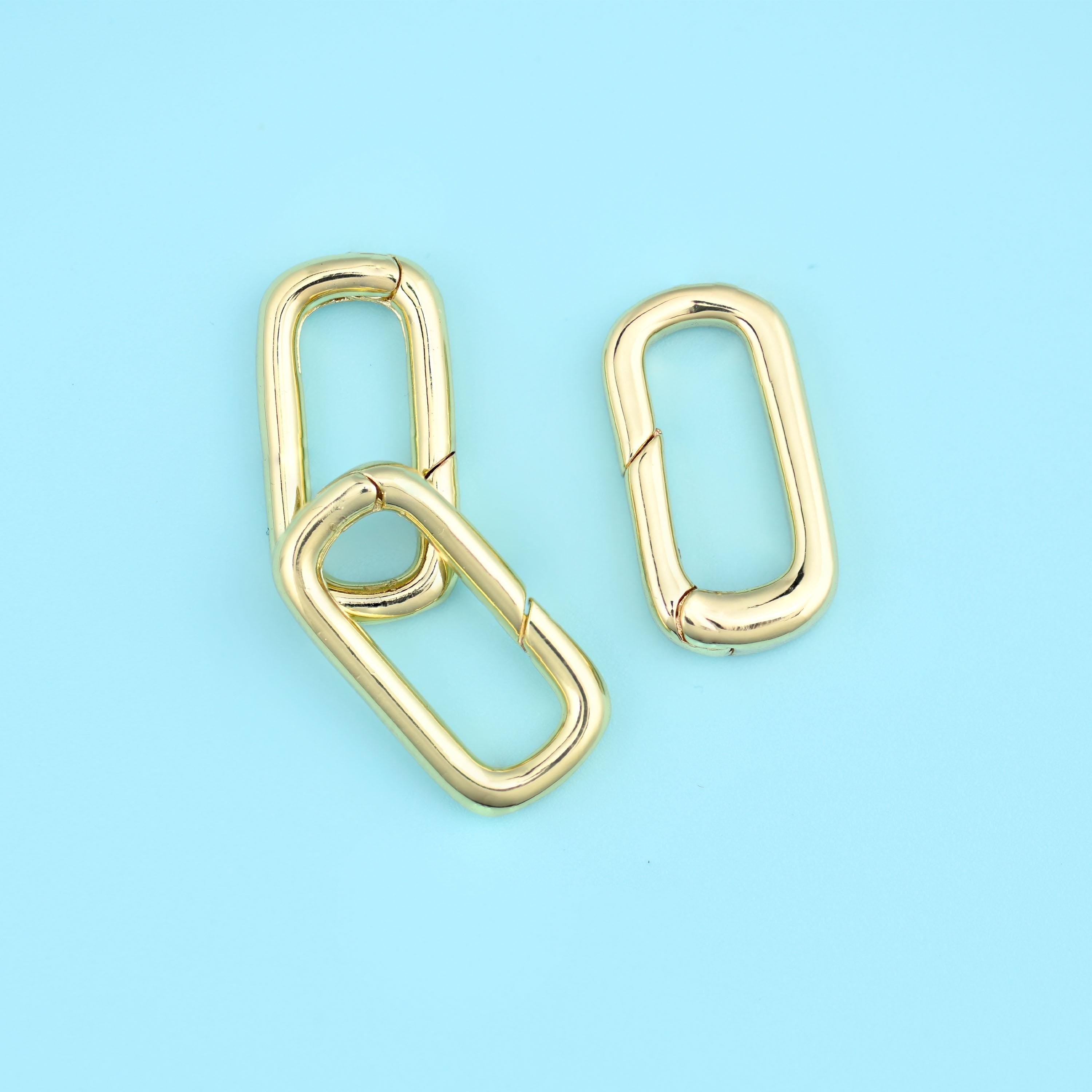 A slim rounded-rectangle carabiner with a spring gate along one long side — press it open, hook it on, and it snaps shut.…