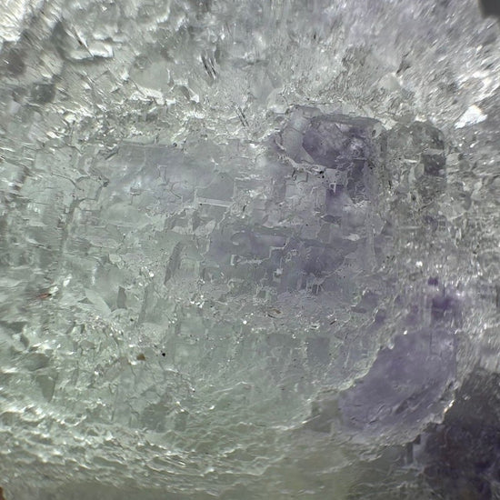 Macro crop of the purple fluorite zone beneath a dusting of tiny white quartz crystals