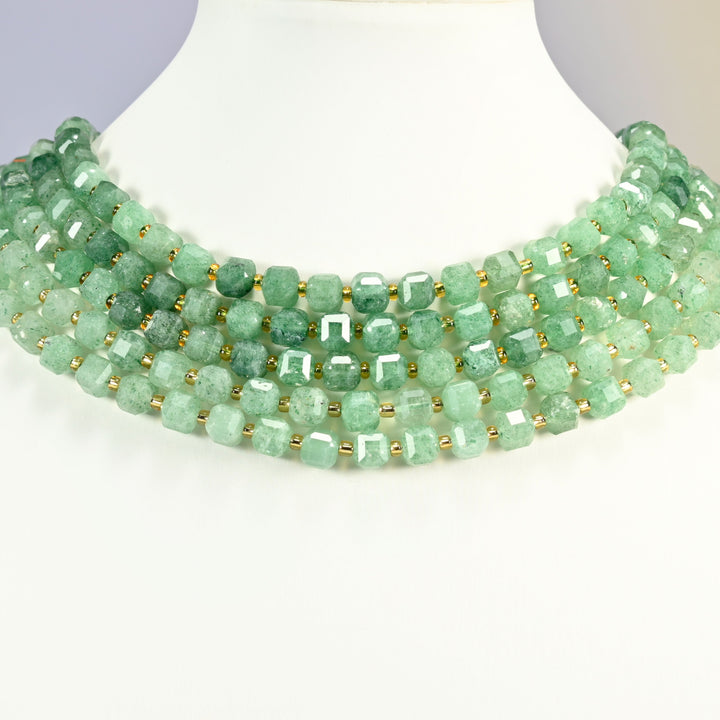 Natural green strawberry quartz faceted cube strands arranged as a layered collar on a white neck display bust