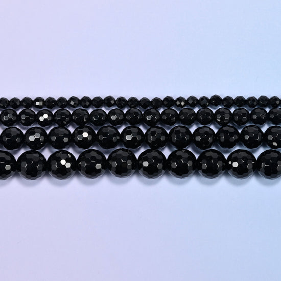 Black onyx faceted round beads in three straight rows, bead size growing from the back row forward.