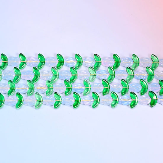 Close-up macro view of white tulip and green leaf glass beads in a dense repeating chevron pattern on a lavender and pink gradient background.