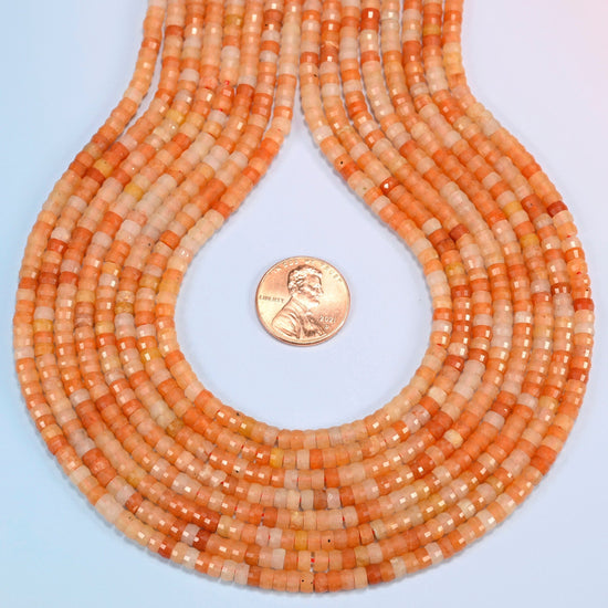 Red aventurine faceted heishi disc strands formed into a teardrop loop around a US penny for scale