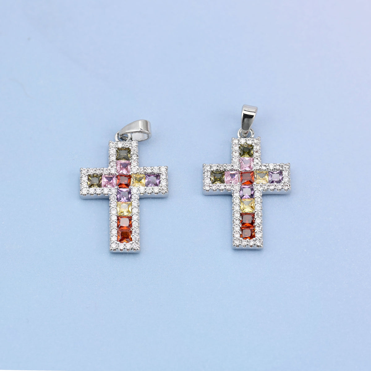 Zirconia cross charms, two white gold plated pendants shown front on with multicolour stones