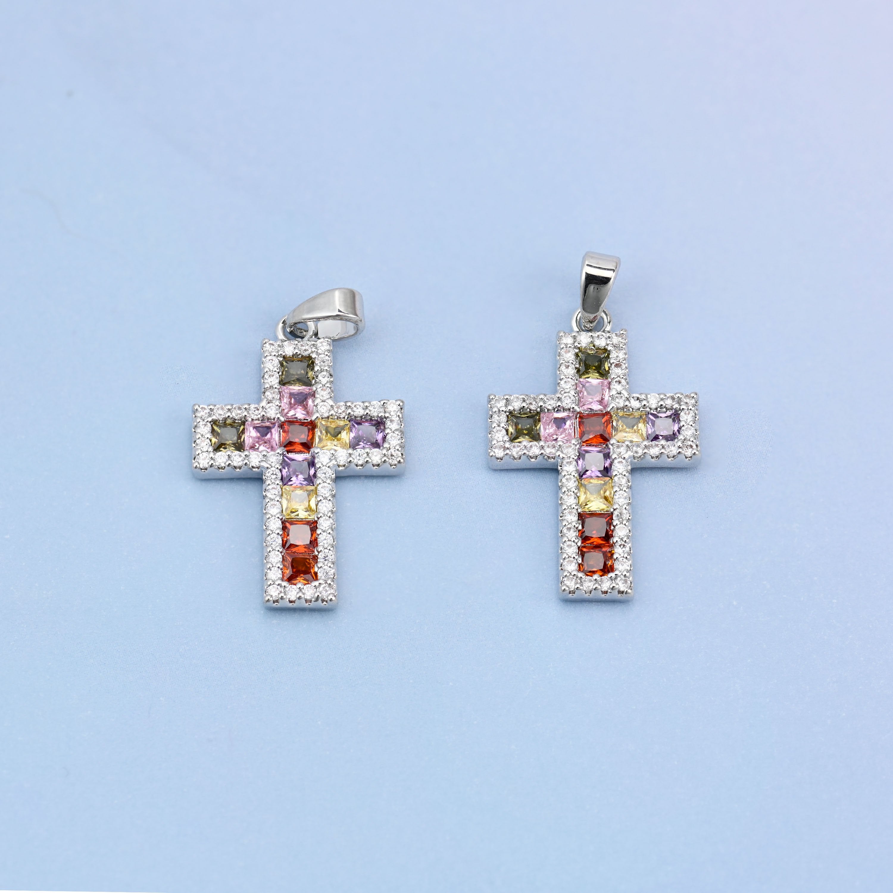 Zirconia cross charms, two white gold plated pendants shown front on with multicolour stones