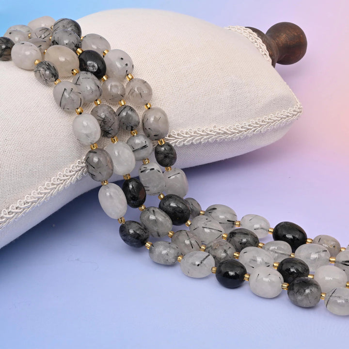 Natural Black Rutilated Quartz oval nugget beads with visible rutile needle inclusions.