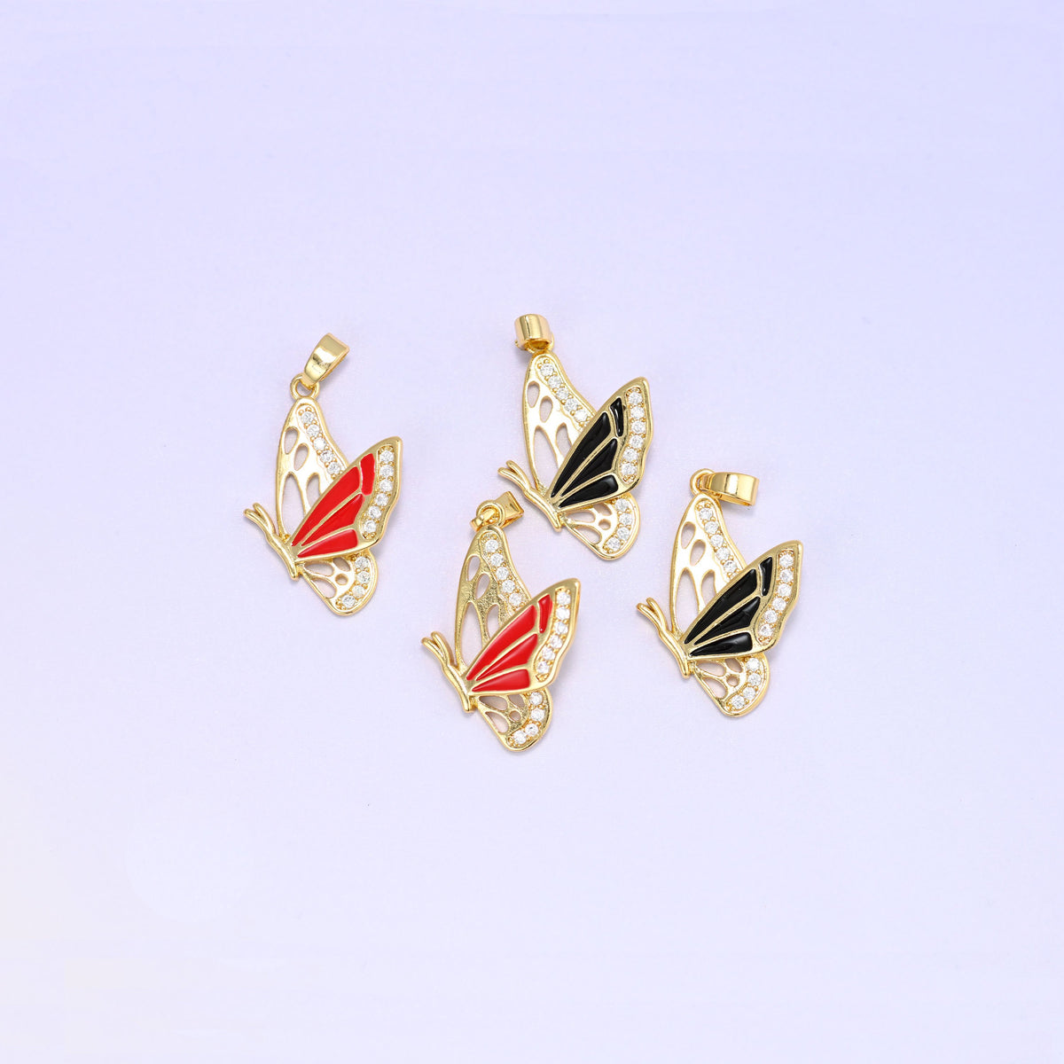 Four flying butterfly charm pendants angled together, two red and two black enamel pieces showing the raised wing flying profile and gold bails.