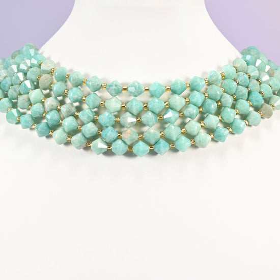 Green Amazonite faceted bicone beads 8mm with gold-tone spacers, strand wrapped around a display bust like a choker necklace