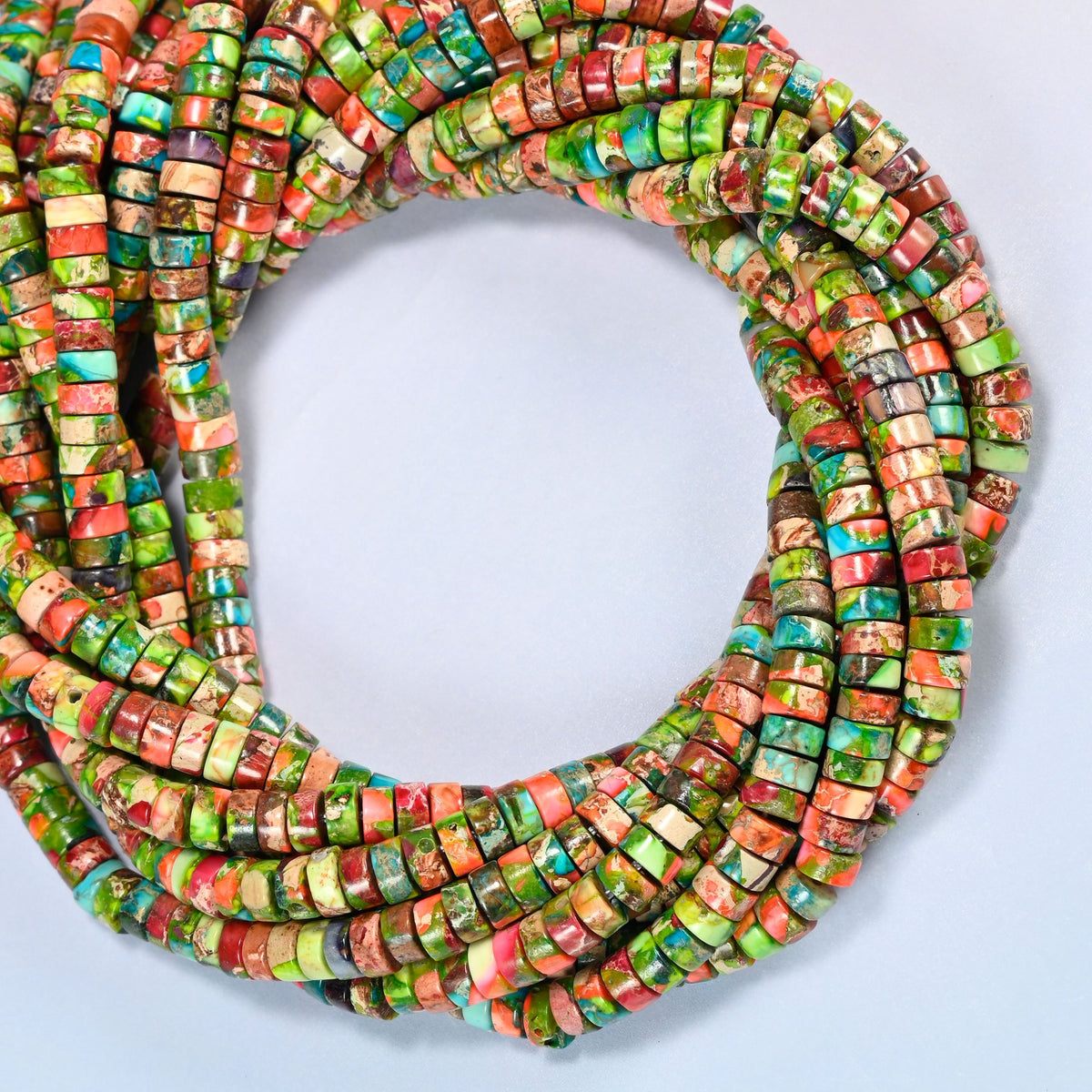 Dyed blue green sea sediment jasper heishi disc beads 2x4mm coiled into overlapping loops, whole strands of lime green, coral orange and turquoise discs