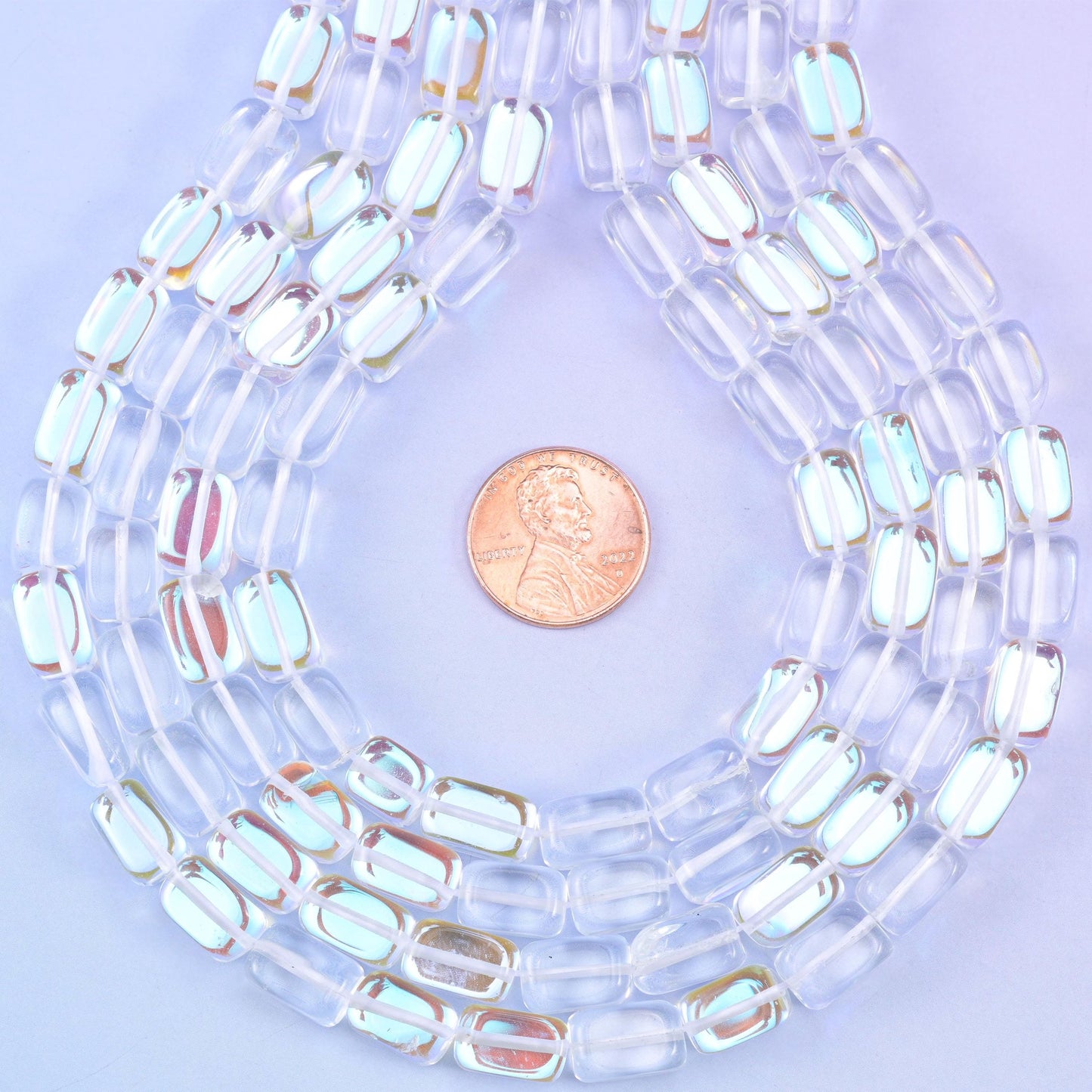 Crystal clear rectangle glass beads with a high gloss polish and a Mystic Aura coating that scatters pale rainbow light across each flat surface