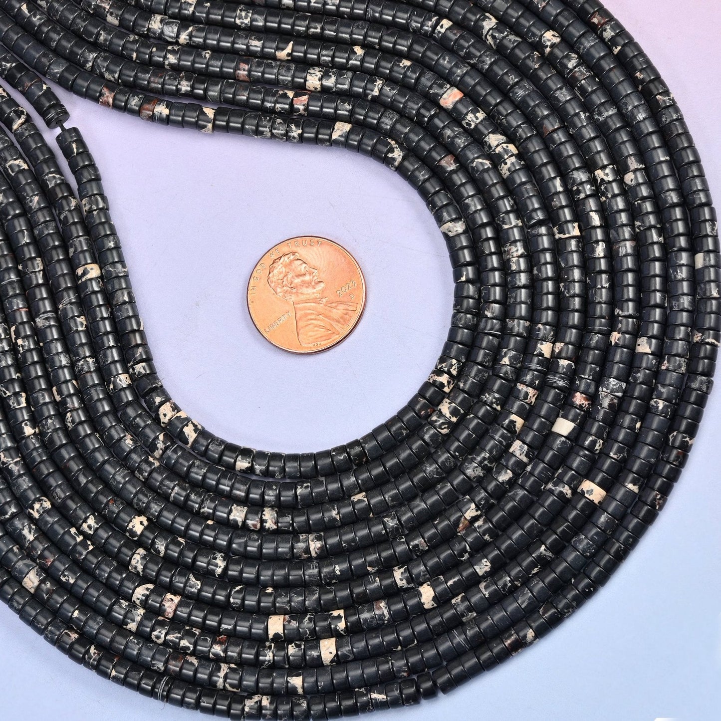 Deep black discs broken up by patches of cream and white marbling, polished flat and slim — a high-contrast neutral that reads graphic rather than plain.