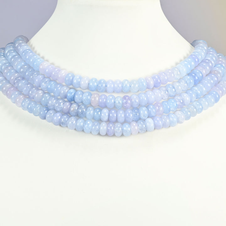 Aquamarine Blue dyed jade gemstone rondelle beads shown on a display bust as a layered collar, several strands stepping down in a row