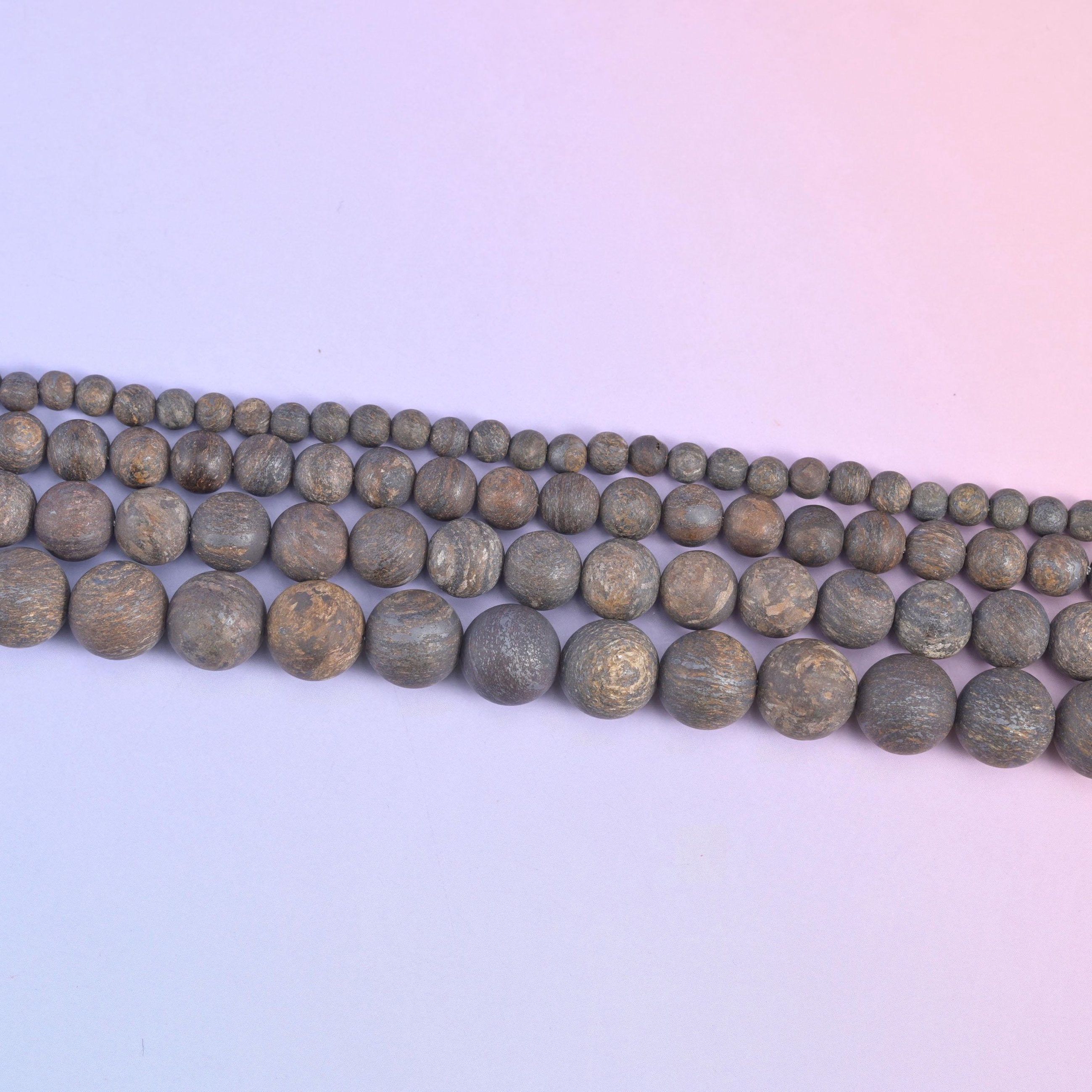 Strands of 4mm through 10mm bronzite rounds running diagonally, the bead sizes stepping up row by row