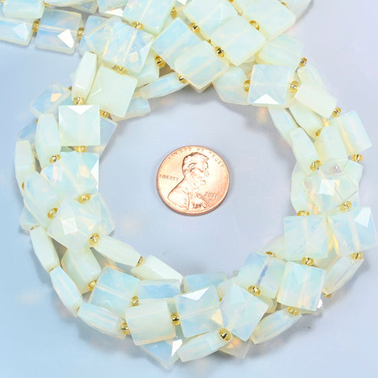 Opalite faceted flat square beads 10x10mm coiled in a loop around a US penny for scale, close-up of the faceted flat square shape