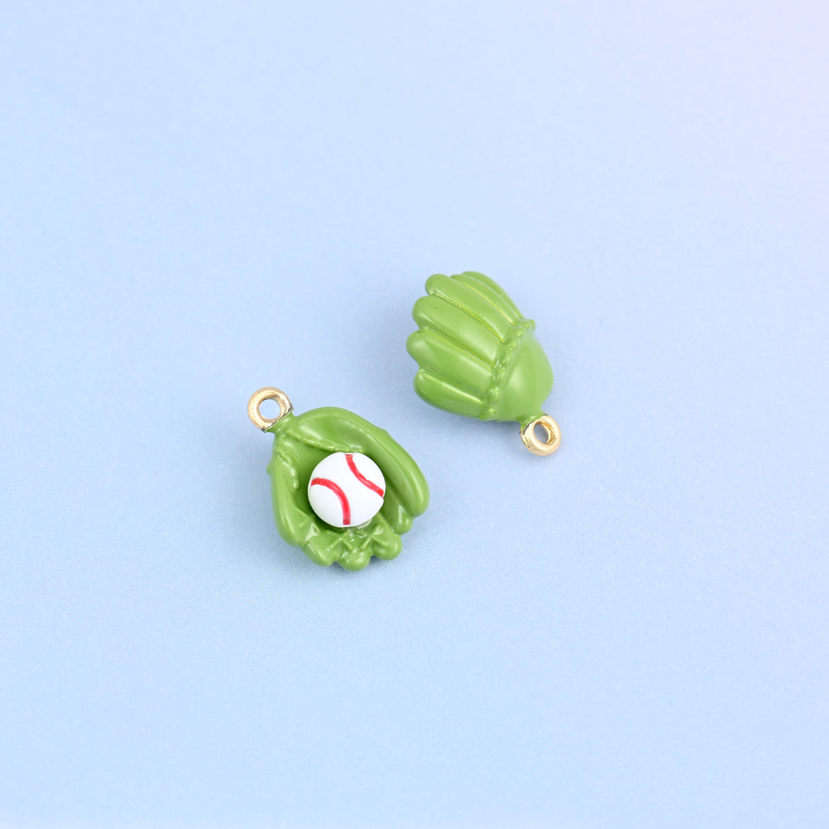 Two green baseball glove charms, one turned to show the moulded back with its own finger stalls.