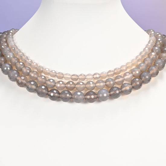 Close-up of gray agate round beads, showing the faceted finish and natural gray tone.