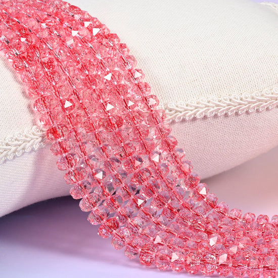 Transparent red faceted rondelle glass beads in clear watermelon red with a warm coral cast