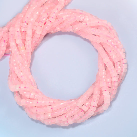 Rose quartz faceted heishi disc beads coiled into overlapping loops, whole strands of soft pink stone