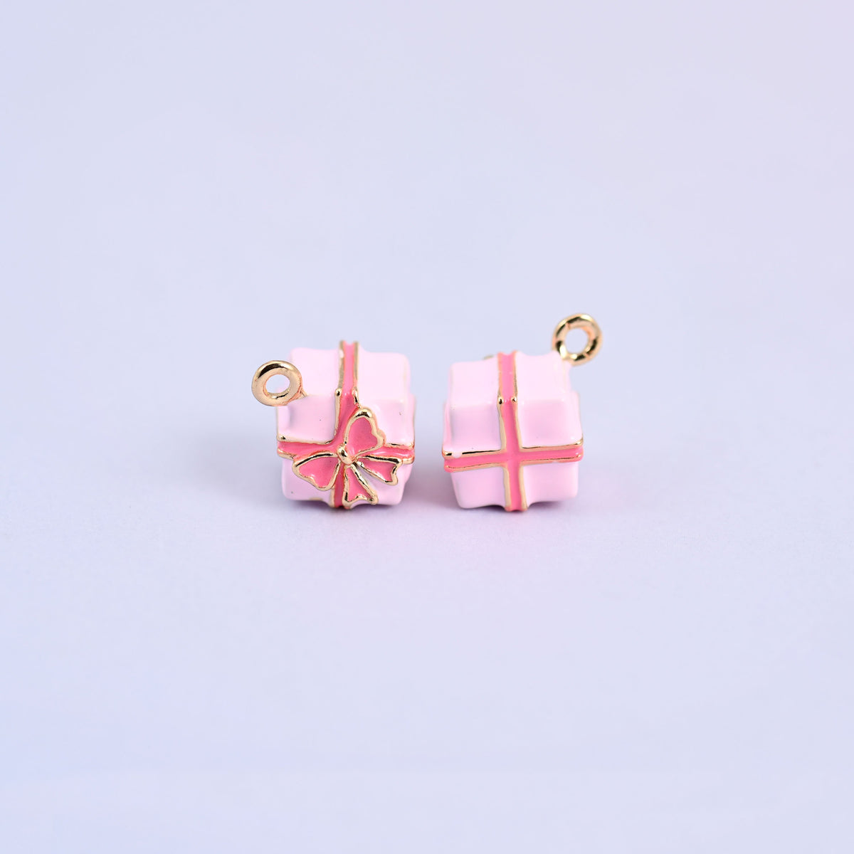 Two light pink gift box charms with pink enamel ribbon and bow.