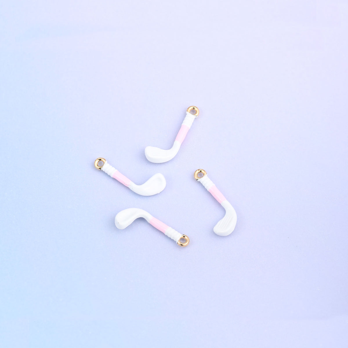 Four white golf club charms with light pink grips.