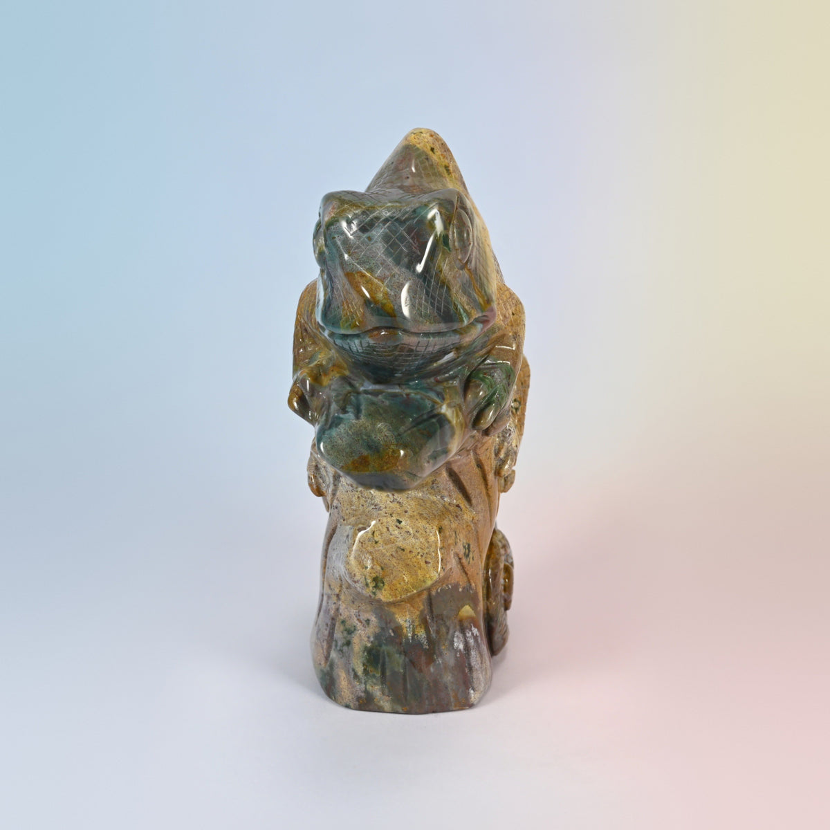 Front view of the ocean jasper chameleon carving, head and front feet gripping the branch