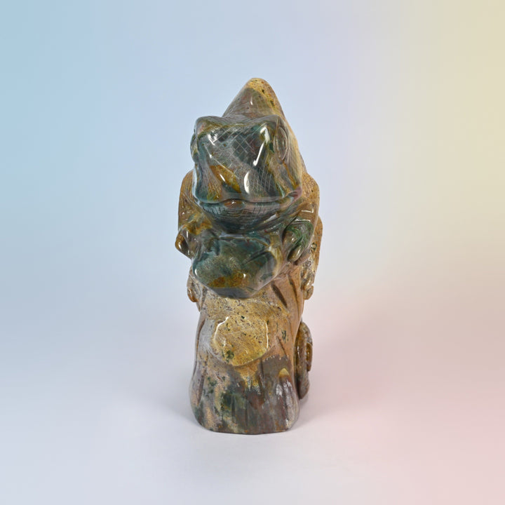 Front view of the ocean jasper chameleon carving, head and front feet gripping the branch
