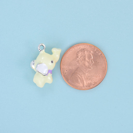 A chubby little elephant modelled fully in the round rather than stamped flat — glossy pastel enamel in baby pink, powder…