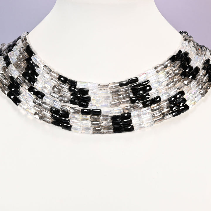 Black gray and clear faceted rectangle glass beads laid in collar rows, showing the repeating 7x4mm pattern across every strand