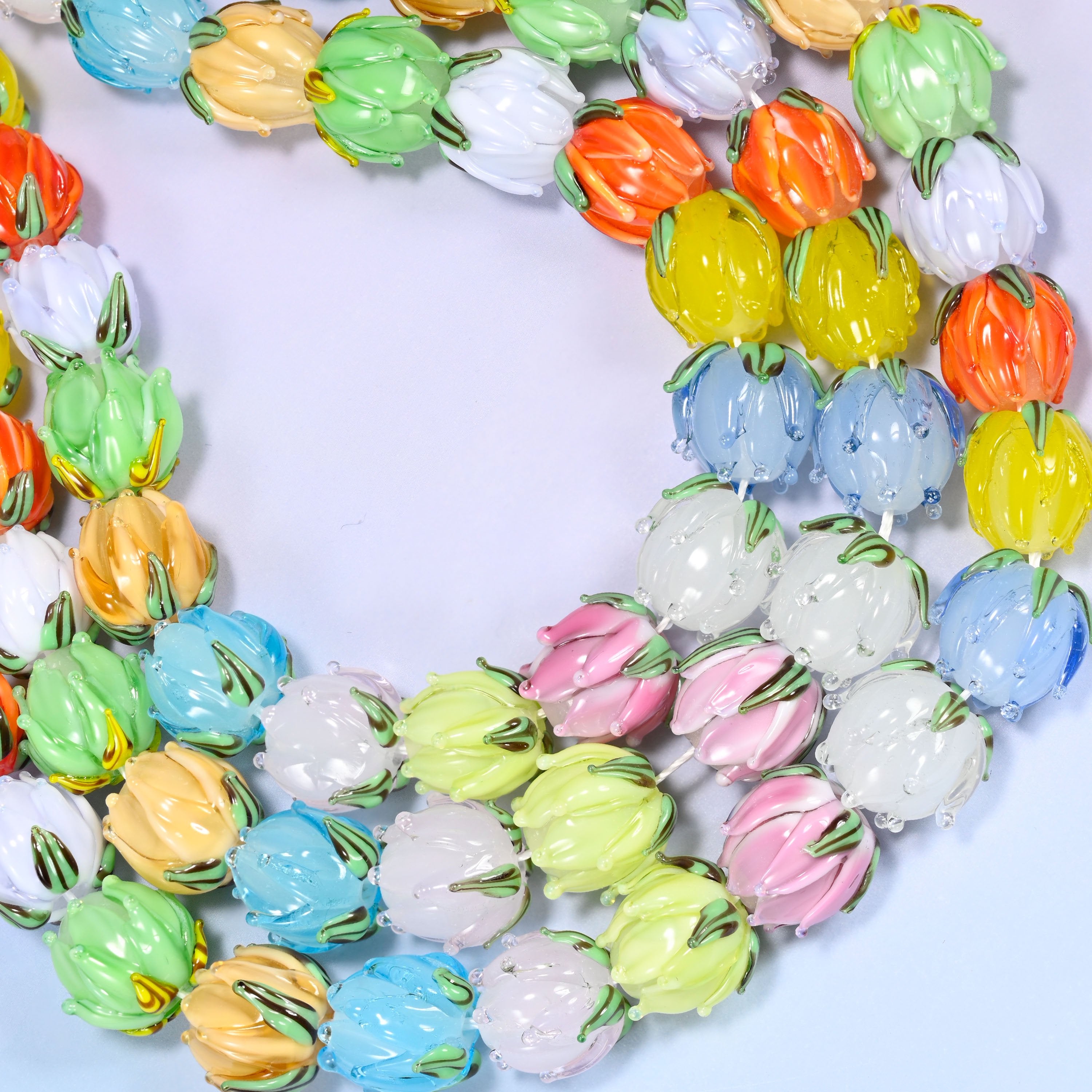 Close-up circular coil of multicolor tulip bud lampwork glass beads, showing the dense flower pattern from a different crop.