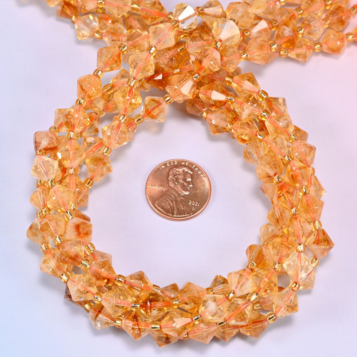 Citrine bicone beads coiled into a round ring, 8mm beads with gold-tone spacers throughout.
