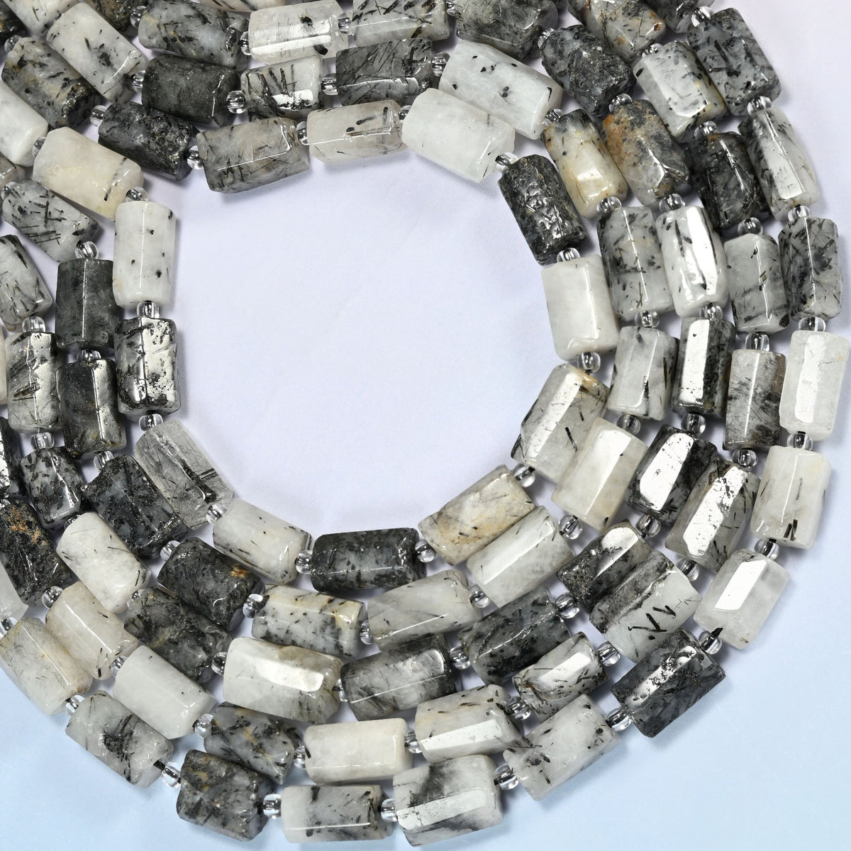 Black rutilated quartz faceted tube beads curved into an open loop, milky white and dark gray beads