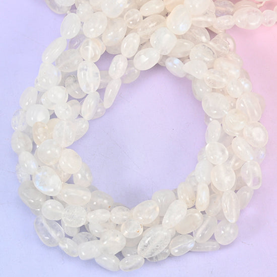 White Moonstone Pebble Nugget Beads — milky white and semi-translucent with a faint cool blue shimmer sliding under the surface, tumbled into smooth rounded nuggets that sit softly against the skin.
