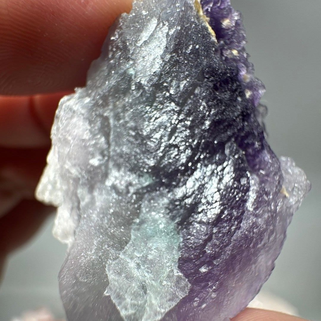 Backlit side of the specimen where the dark purple band sits above a translucent white base