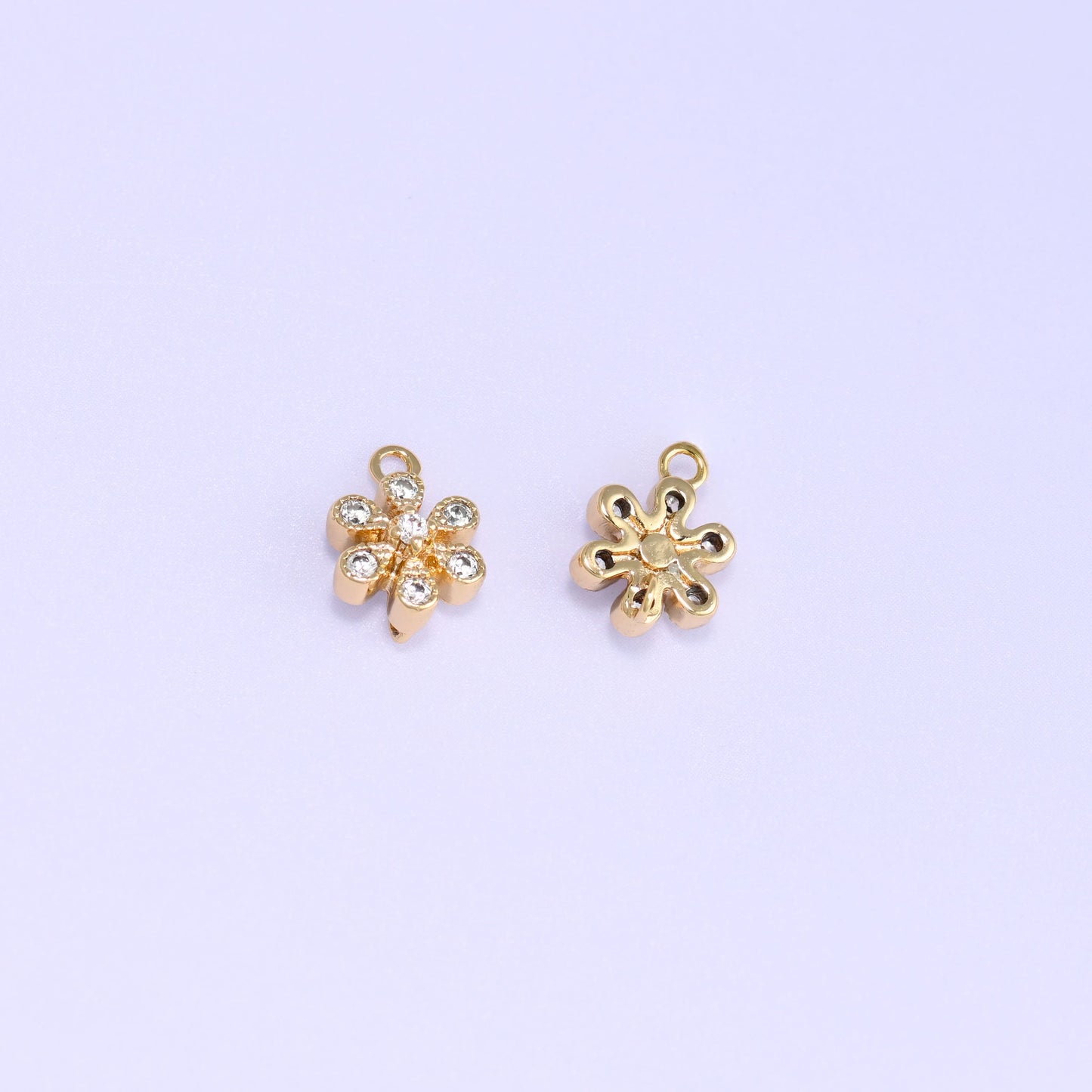 Small gold charms, two flower charms with one turned over to show the back