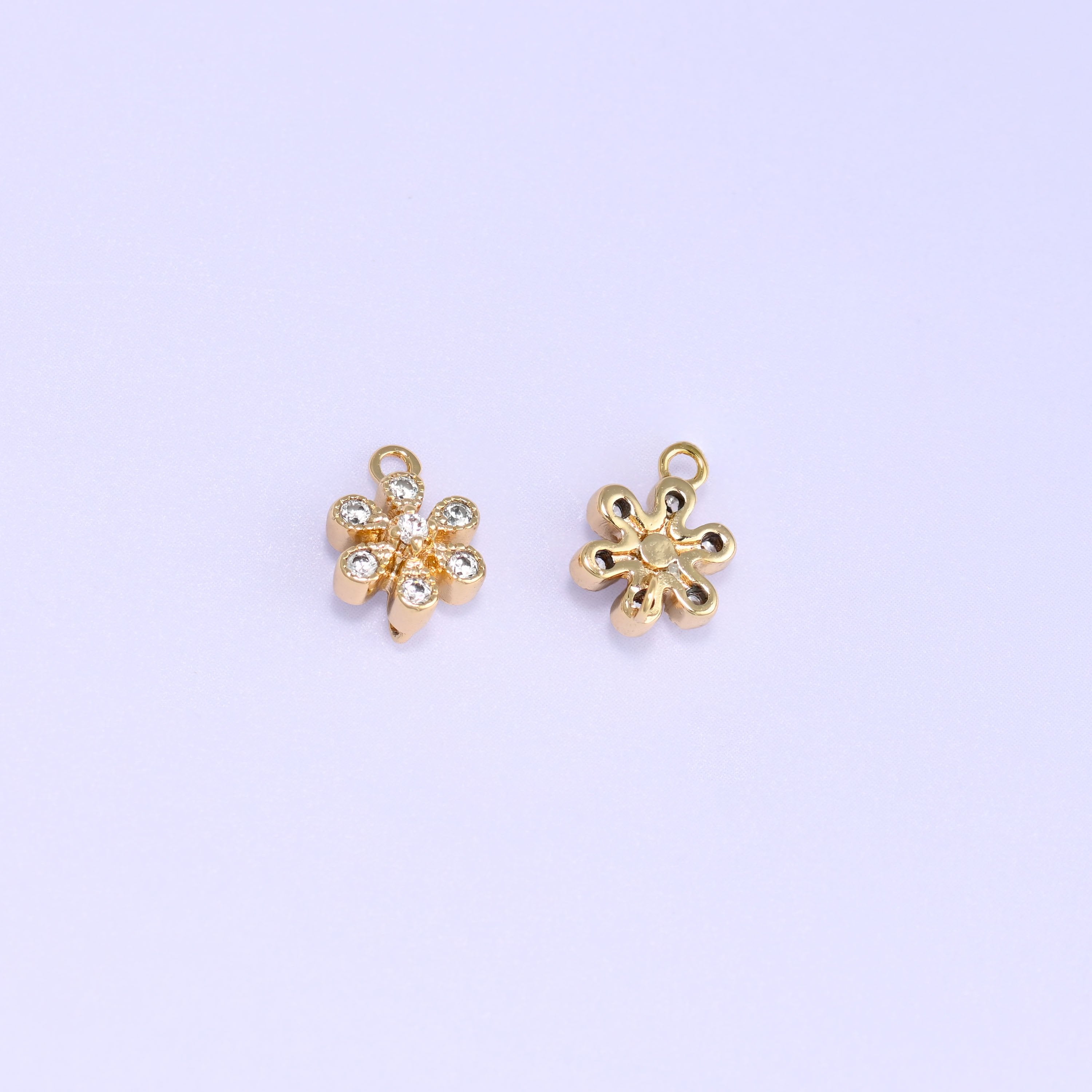 Small gold charms, two flower charms with one turned over to show the back