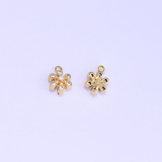 Small gold charms, two flower charms with one turned over to show the back