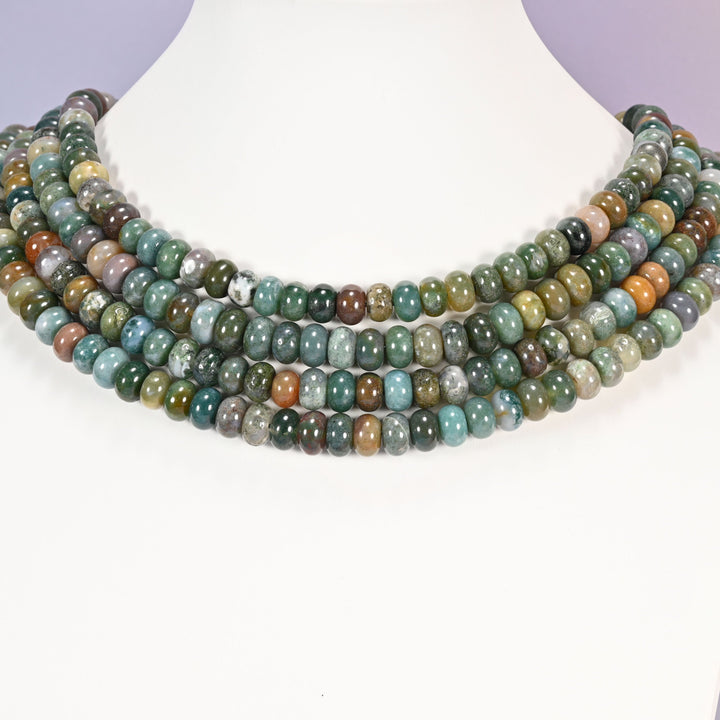 Multi-strand Indian Agate necklace laid flat on a mannequin neck form against a lavender background.
